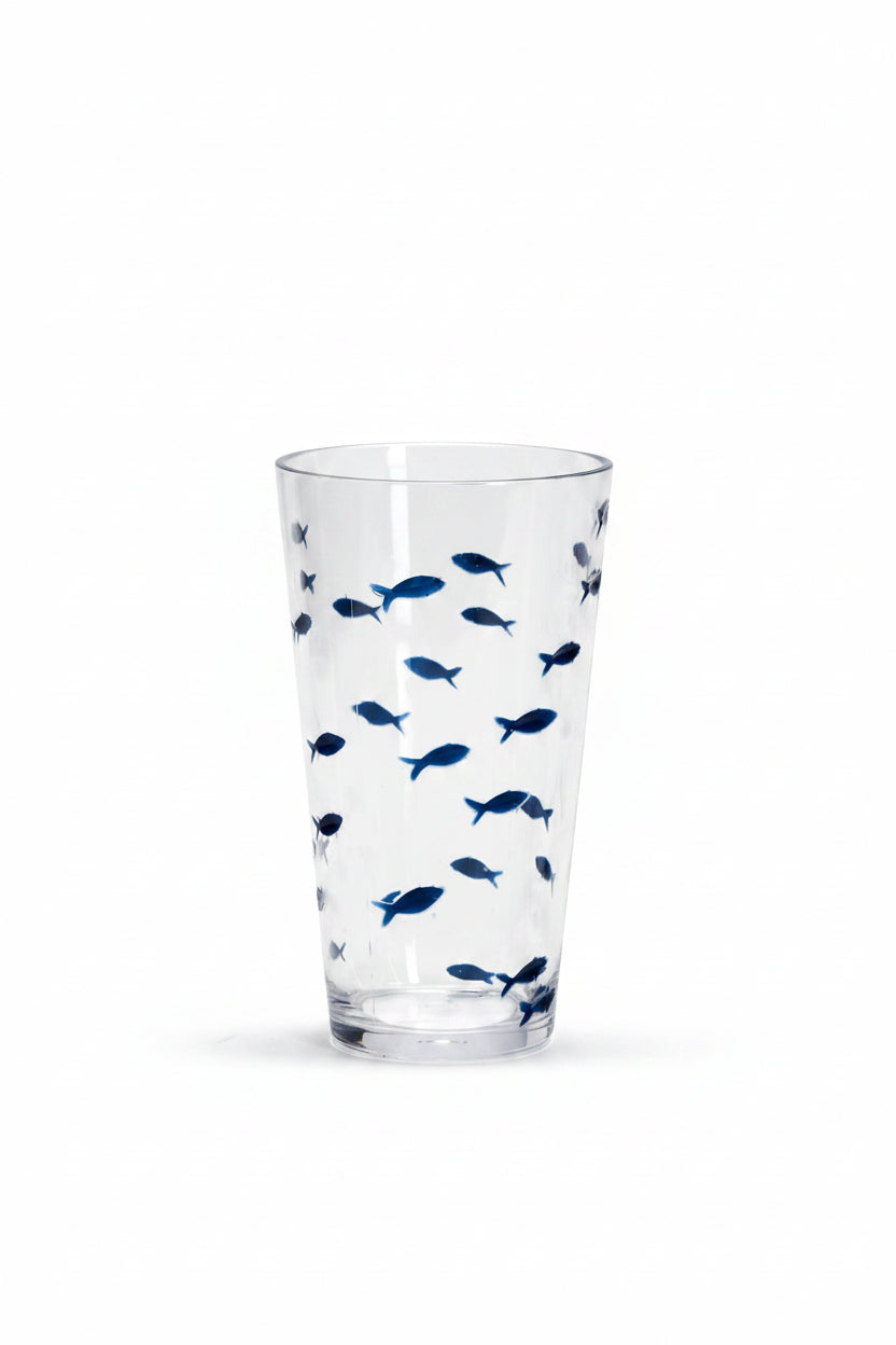 A clear drinking glass decorated with a pattern of small blue fish.