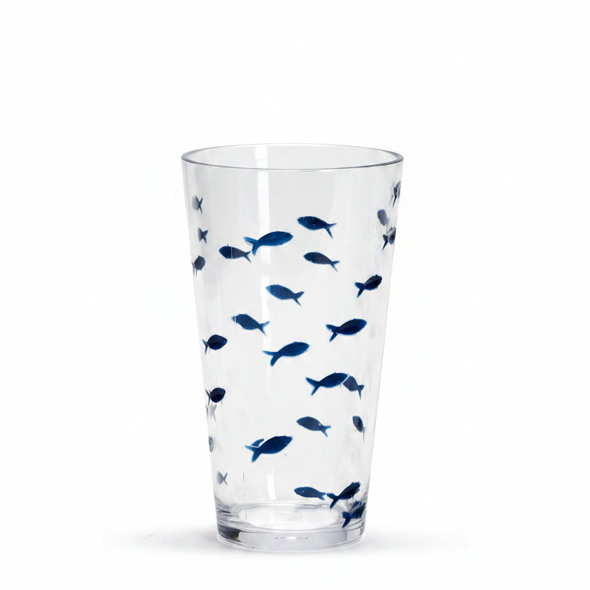 A clear drinking glass decorated with a pattern of small blue fish.
