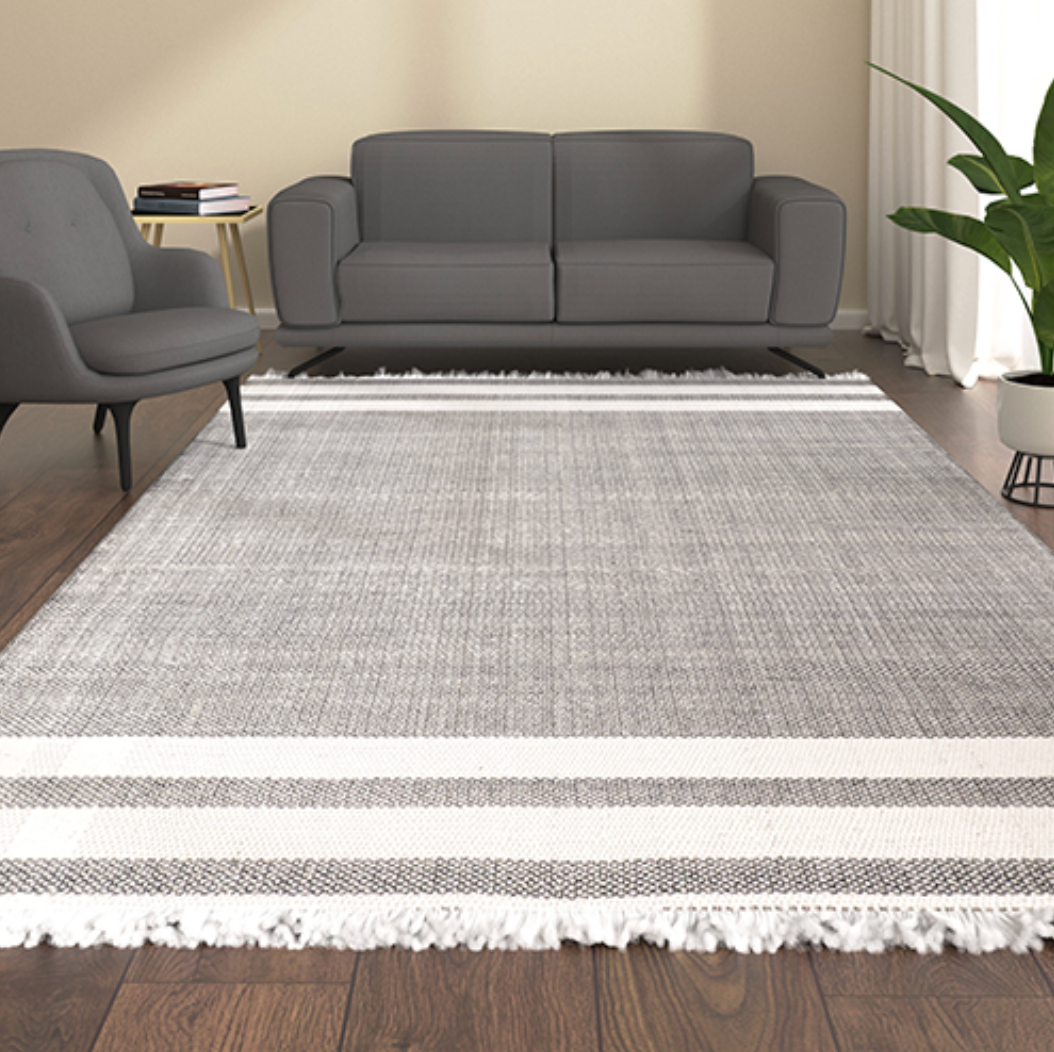 A rectangular area rug with a textured gray and white striped pattern.