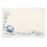 An off-white woven placemat with a blue crab and blue seaweed branch design in the lower-left corner.