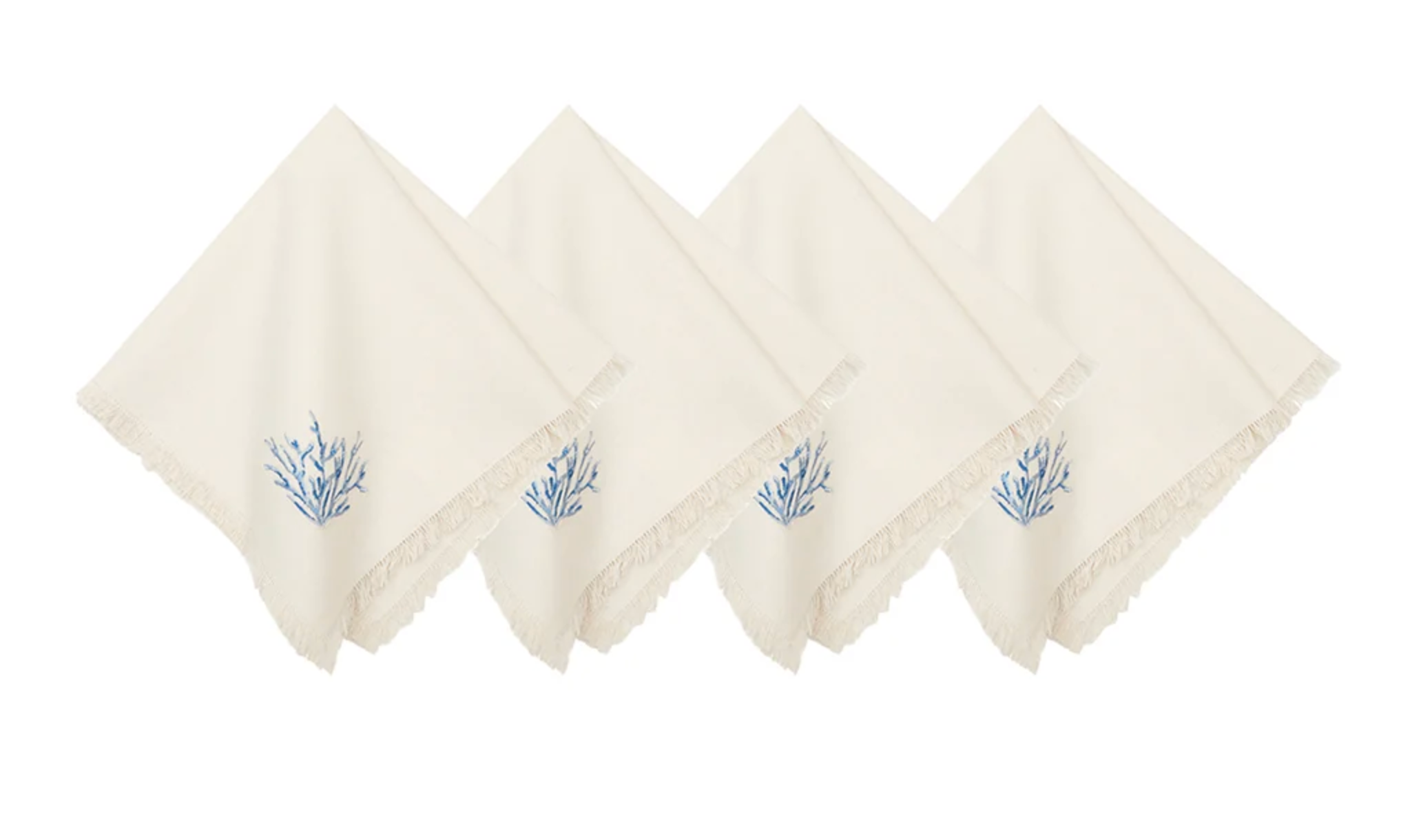 Four off-white cotton napkins with fringed edges and a small blue botanical embroidery on the corner.