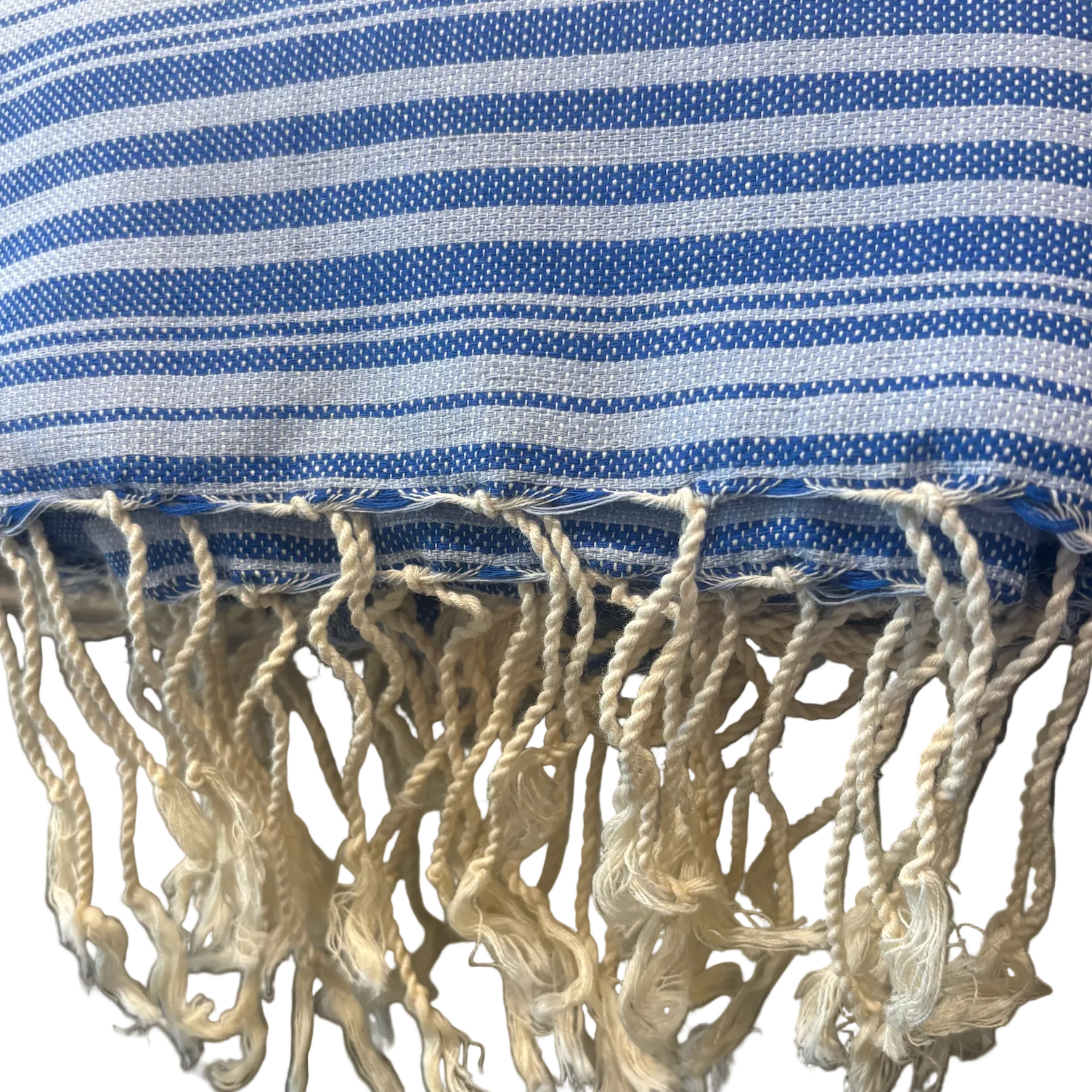 A close-up of a blue and white striped woven textile with fringed tassels along the bottom edge.