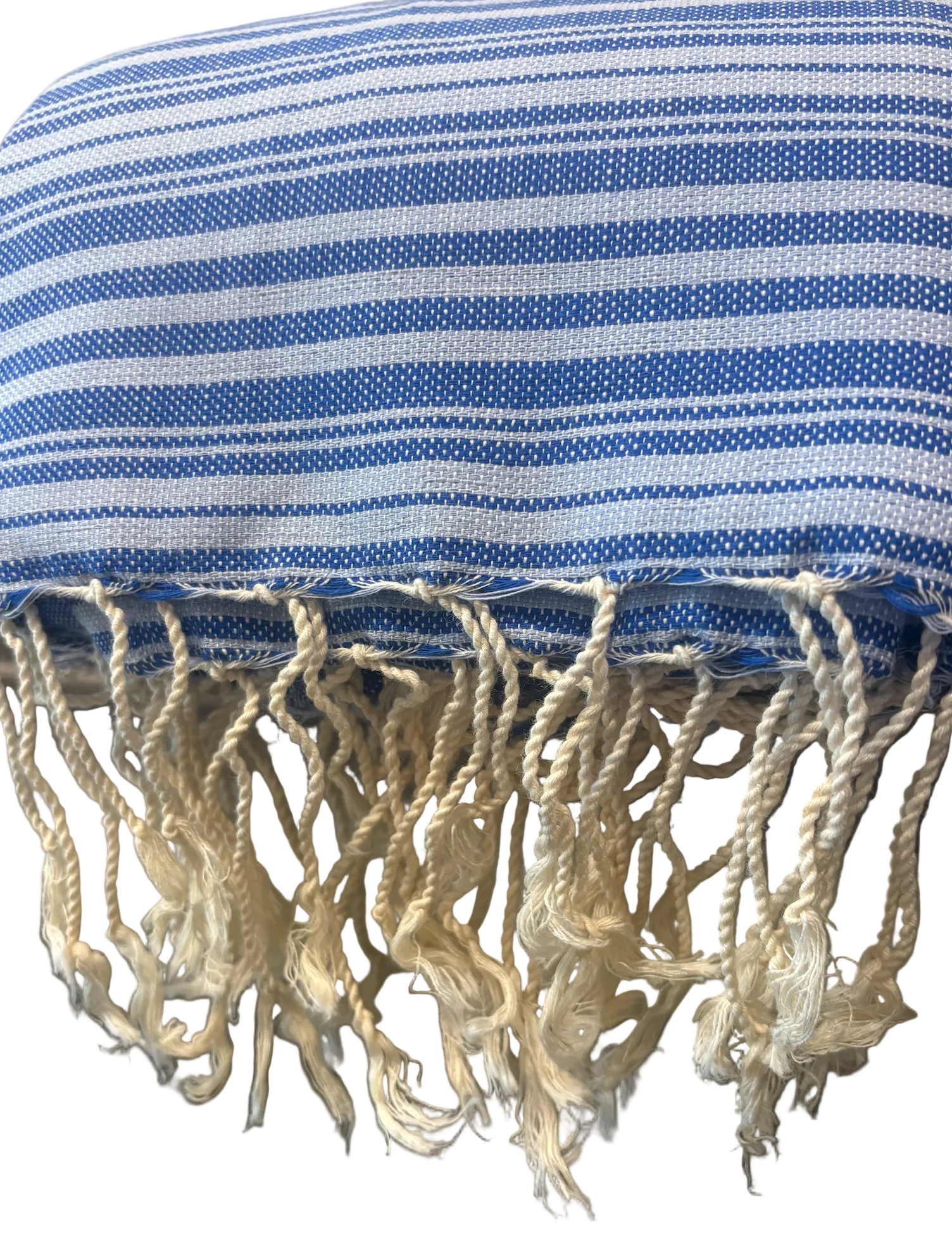 A close-up of a blue and white striped woven textile with fringed tassels along the bottom edge.