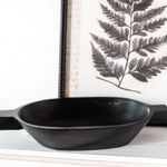 A black wooden bowl with handles displayed on a table.