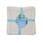 A folded set of white embroidered cocktail napkins with a light blue ribbon and a blue hydrangea-shaped paper tag.