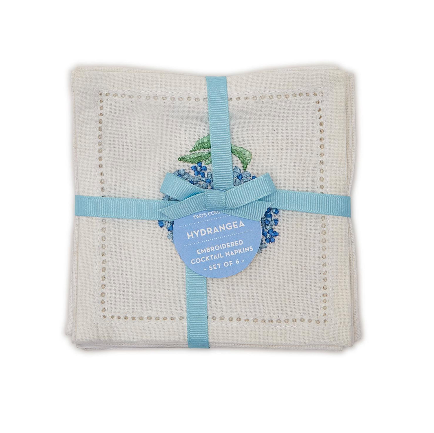 A folded set of white embroidered cocktail napkins with a light blue ribbon and a blue hydrangea-shaped paper tag.