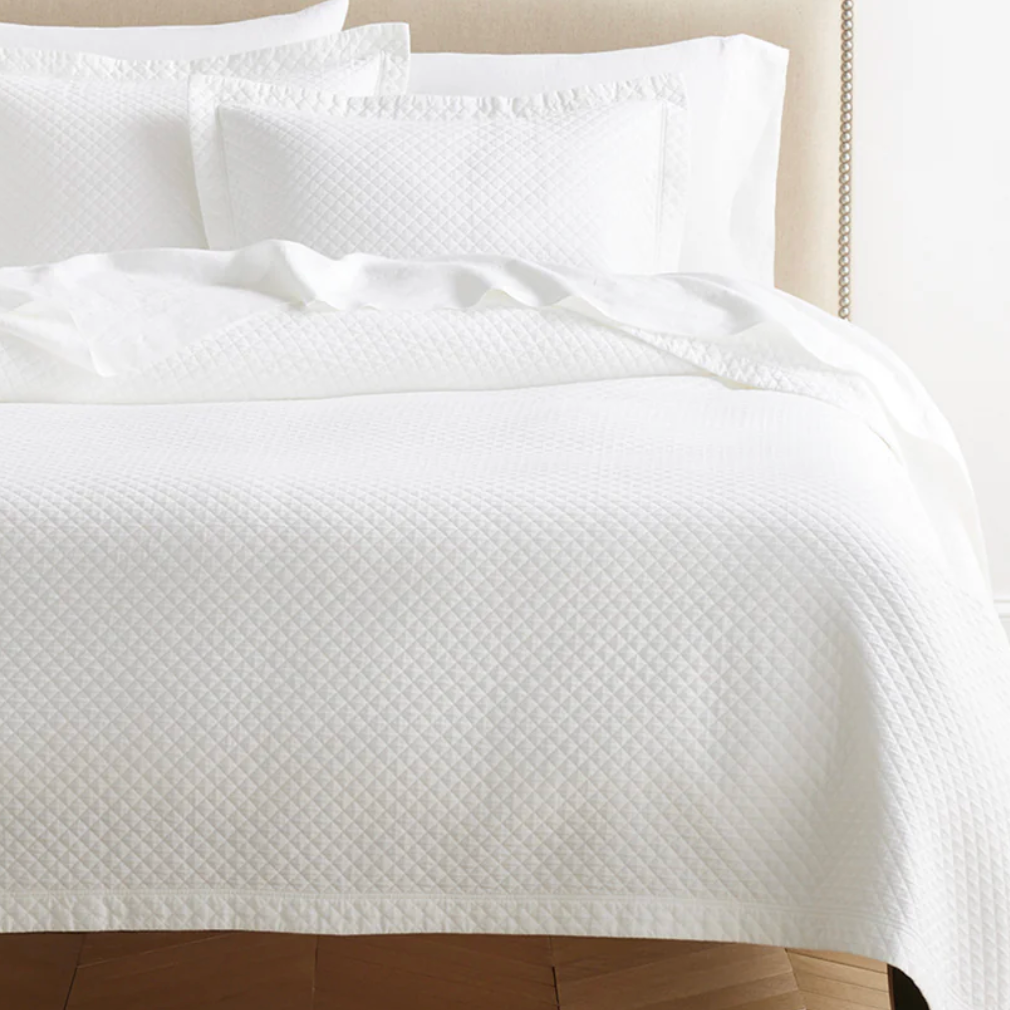 White textured quilt and pillow .