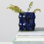 A glossy cobalt blue textured ceramic vase with raised bubble-like circles.
