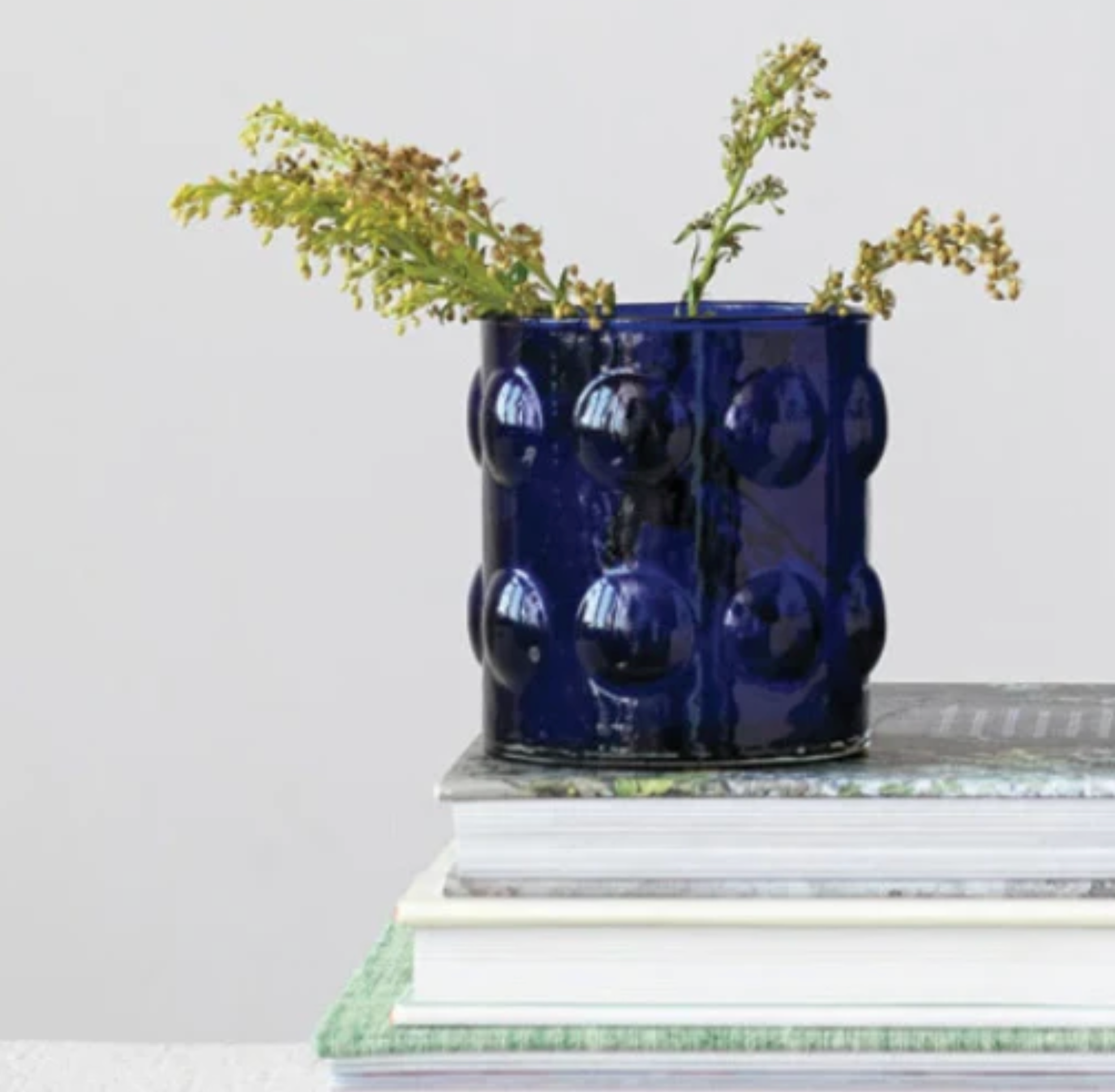 A glossy cobalt blue textured ceramic vase with raised bubble-like circles.