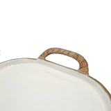 Close-up of a white oval tray or platter with a textured tan woven handle.