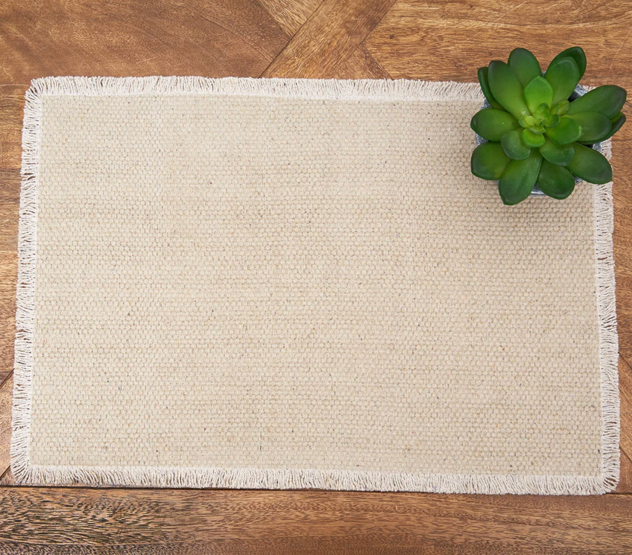 A rectangular natural jute placemat with fringed edges.