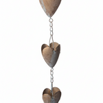 A rustic metal rain gutter ornament featuring three stacked, vertically hanging heart-shaped panels connected by short chains.