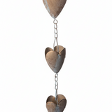 A rustic metal rain gutter ornament featuring three stacked, vertically hanging heart-shaped panels connected by short chains.
