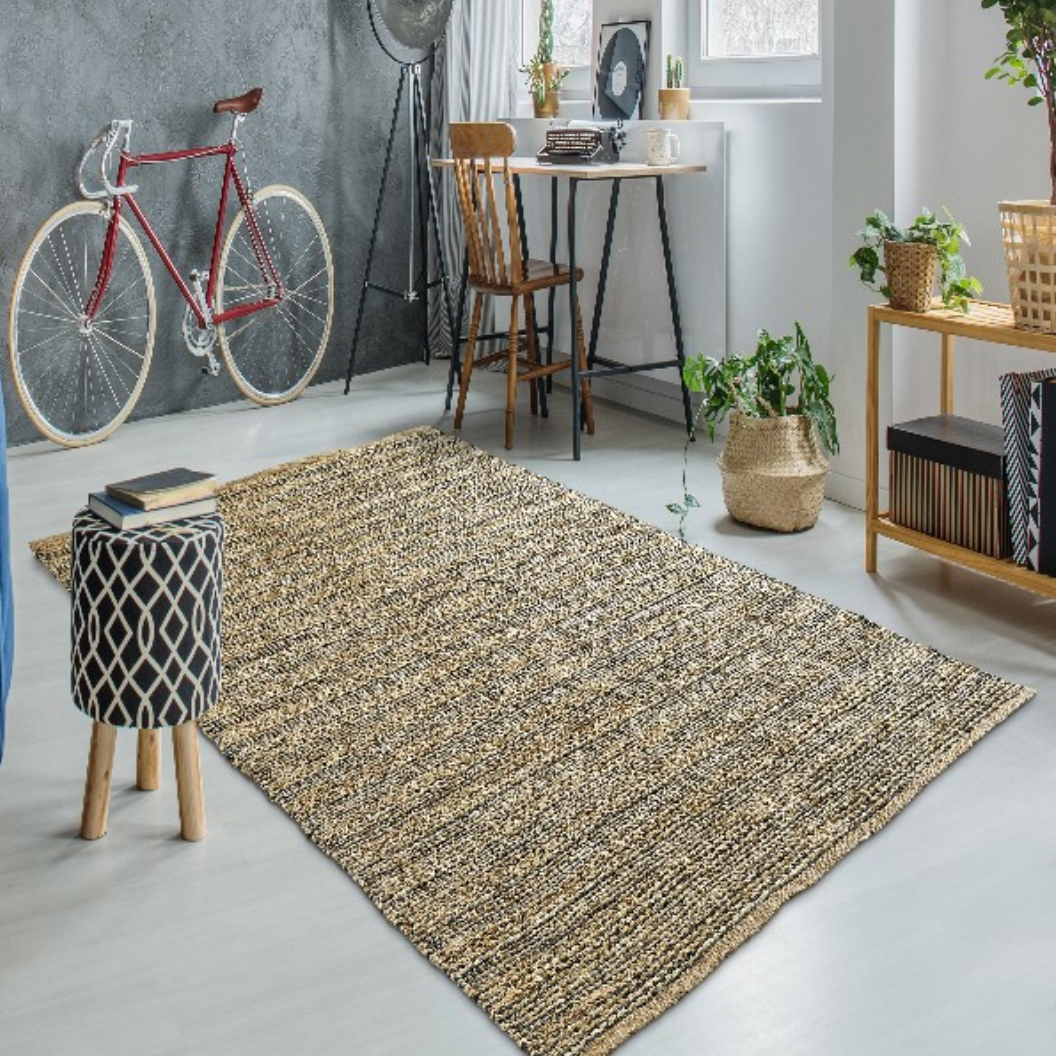A large rectangular woven area rug in beige, brown, and black tones.