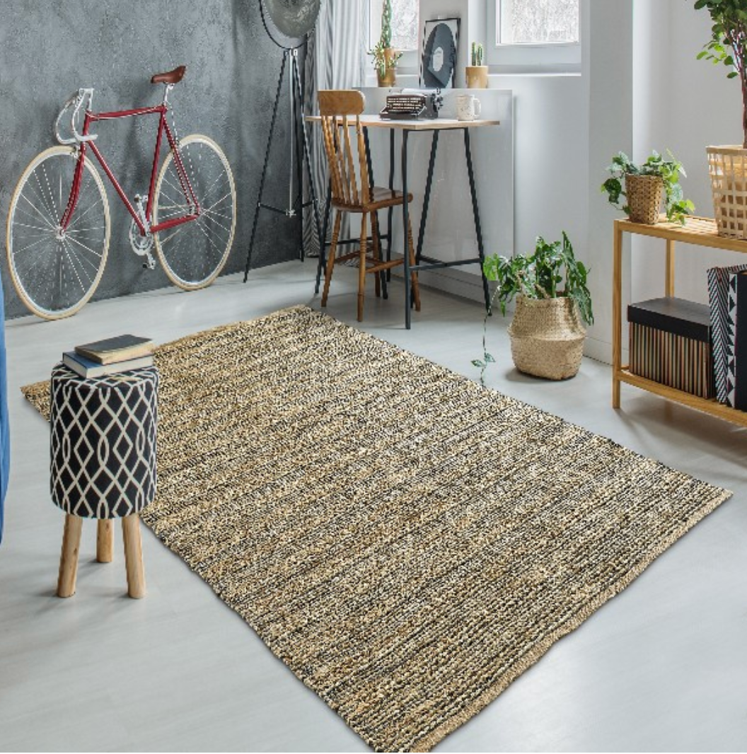 A large rectangular woven area rug in beige, brown, and black tones.