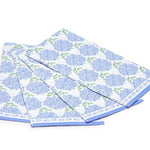 A stack of blue and white paper napkins with a floral pattern, including hydrangea flowers.