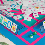 Close-up of a game board with tiles, dice, and card holders.