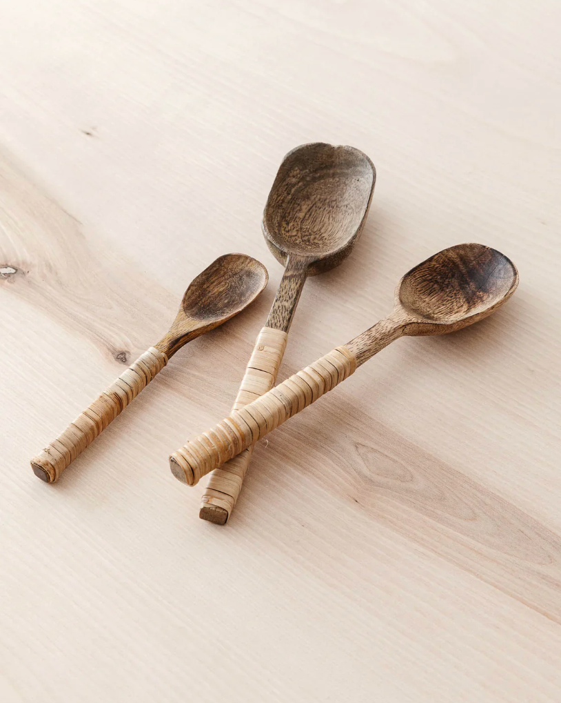 Three hand-carved wooden serving spoons with textured light wood handles.