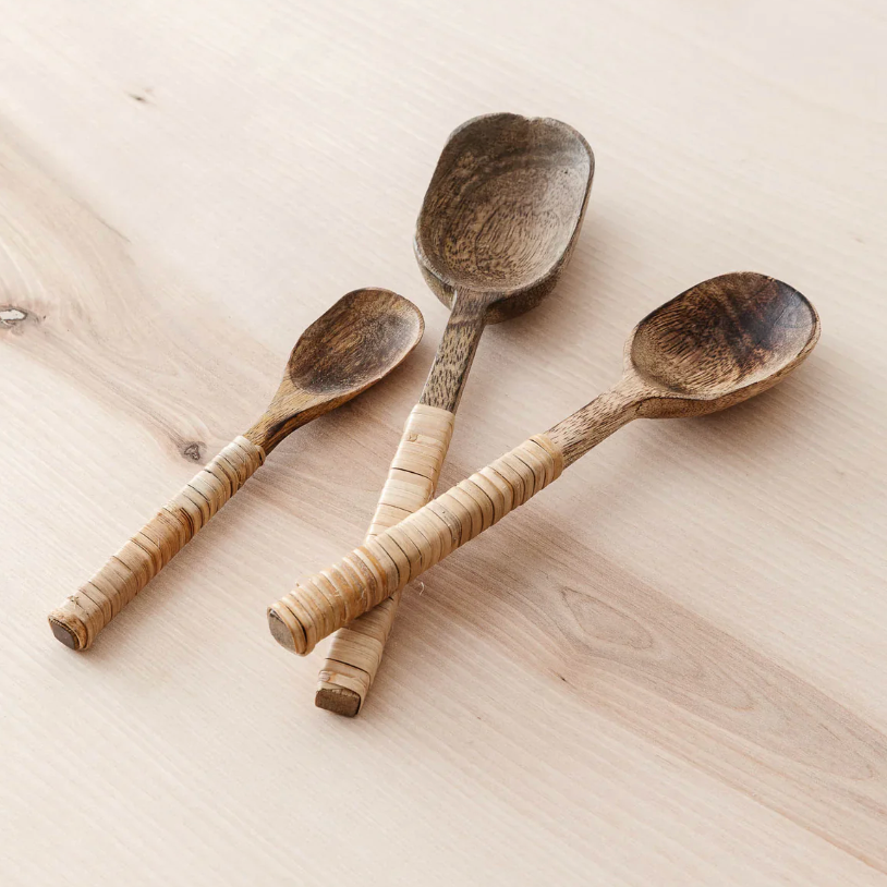 Three hand-carved wooden serving spoons with textured light wood handles.
