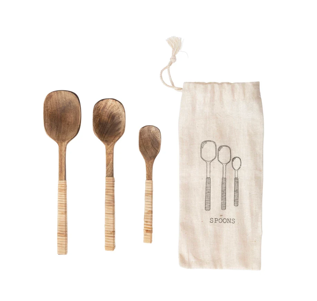 Three hand-carved wooden serving spoons with textured light wood handles.