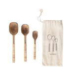 Three hand-carved wooden serving spoons with textured light wood handles.