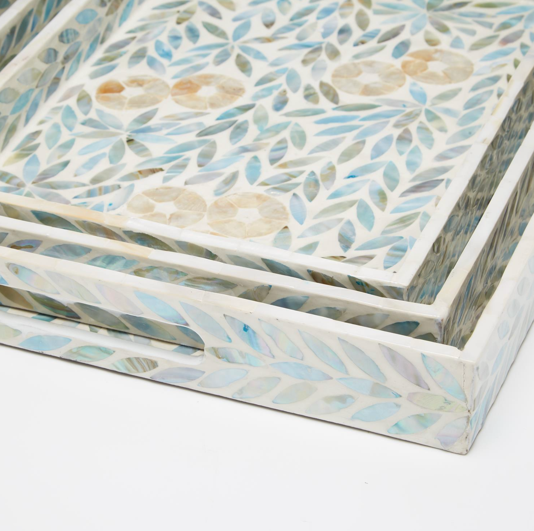 A close-up of a decorative rectangular tray with a mother-of-pearl inlay pattern featuring blue, beige, and white leaf and floral.