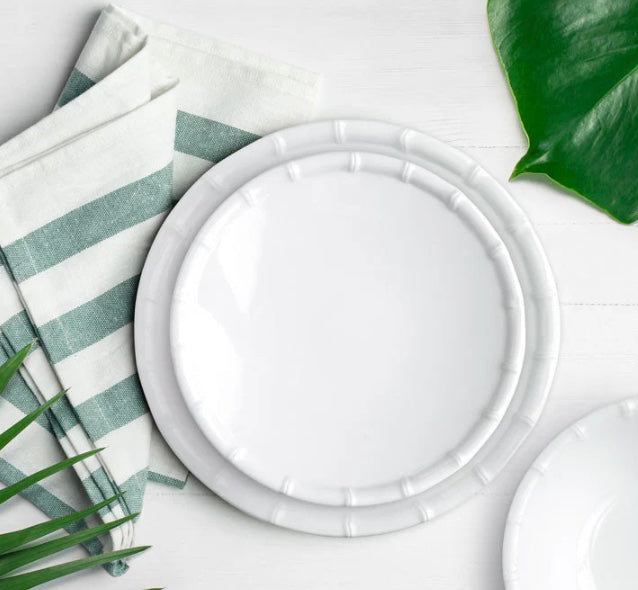 A white round melamine bamboo salad plate with a bamboo pattern border.