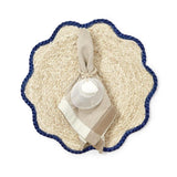 A set of two beige placemats with blue scalloped edges.