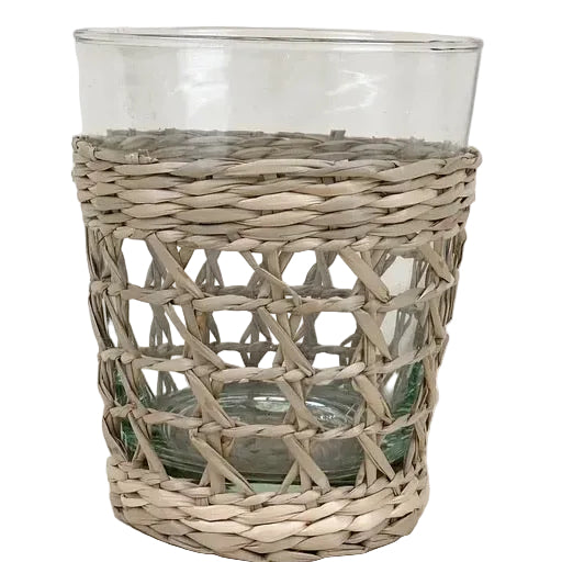 A clear glass tumbler with a woven seagrass cage-like pattern.