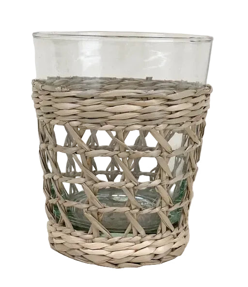 A clear glass tumbler with a woven seagrass cage-like pattern.