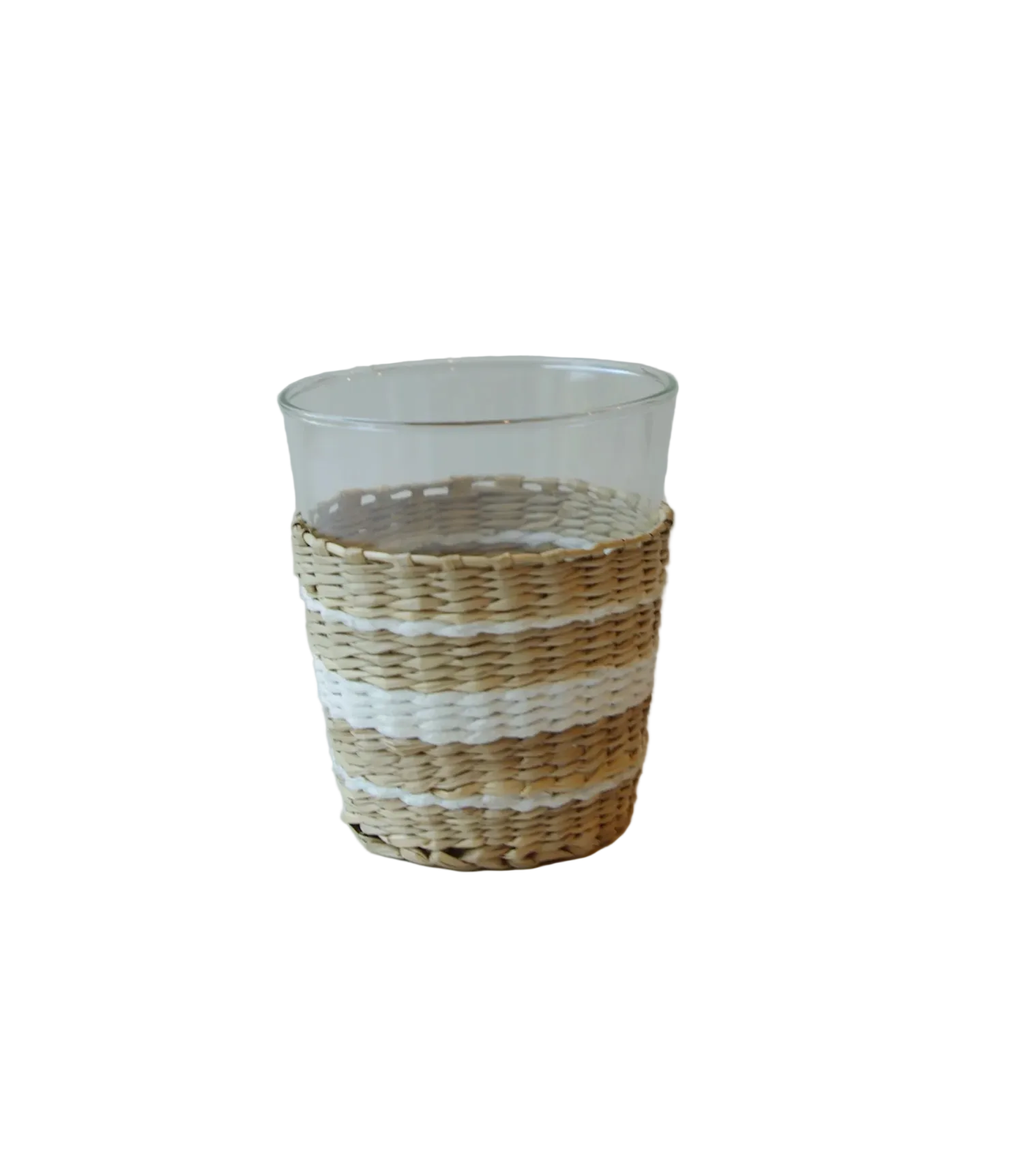 Clear glass tumbler with woven straw base .