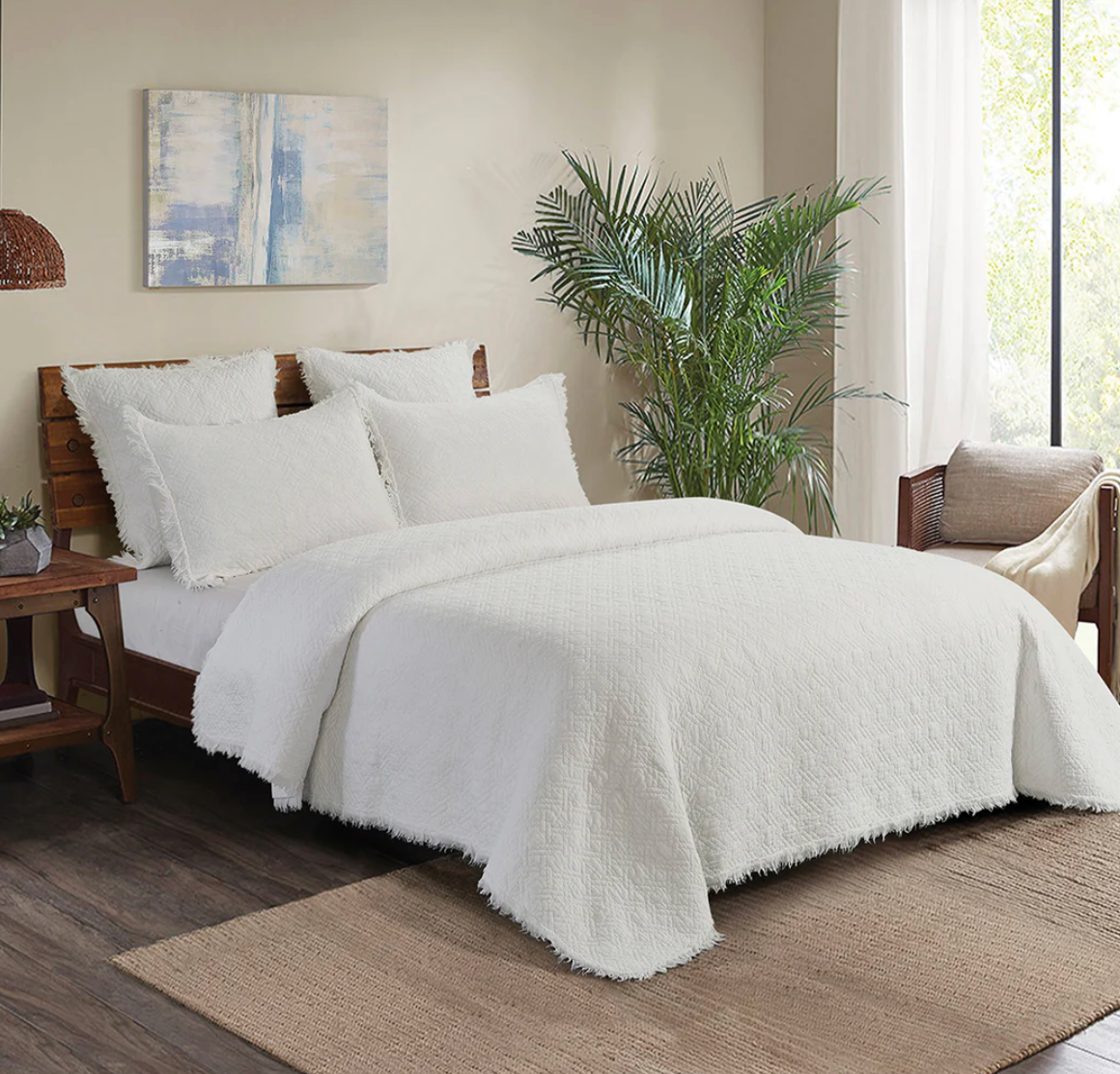 White textured comforter on a bed.