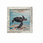 A framed painting of a sea turtle swimming in blue water with sandy shore details, set in a distressed white wood frame 