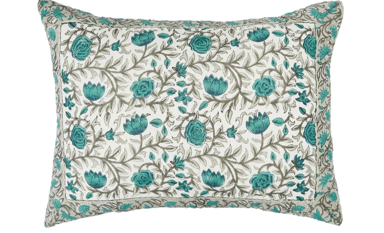 Floral-patterned pillow with teal flowers .