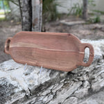 A wooden serving board with handles.